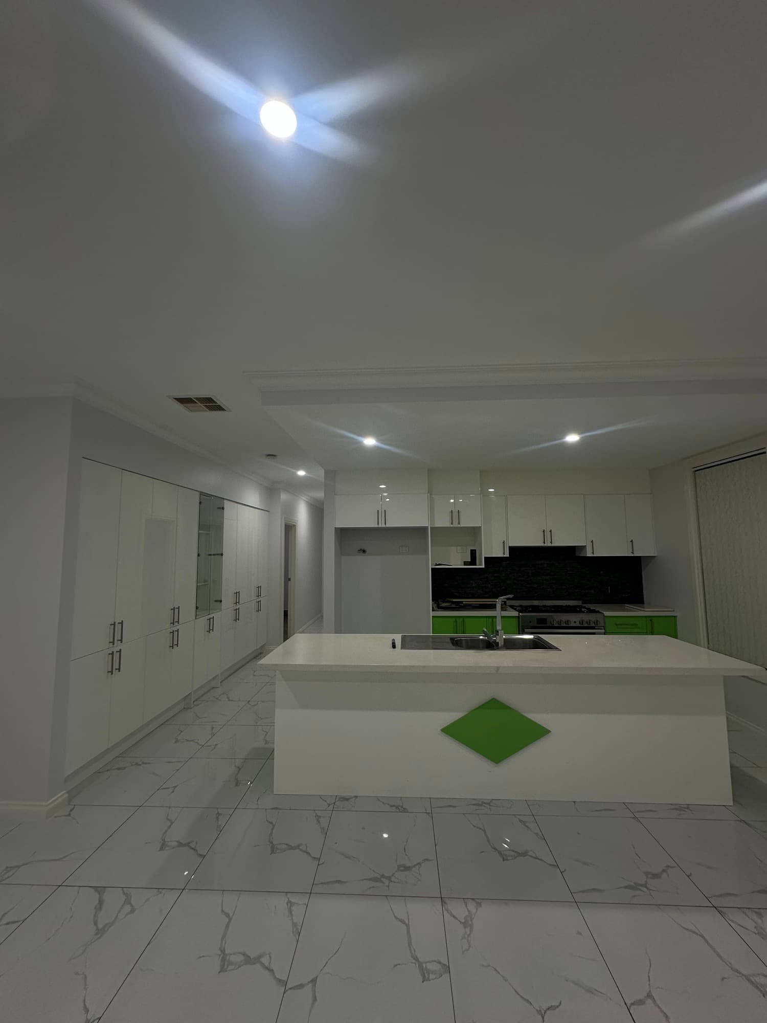 Custom white kitchen with green accents and a large central island